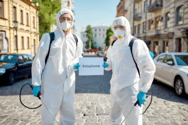 Tetikte olun. Covid19 virüsünün ortaya çıkması nedeniyle şehrin sokaklarının temizlenmesi ve dezenfekte edilmesi. Koruyucu giysiler ve maskeler içinde özel bir ekip üzerinde 