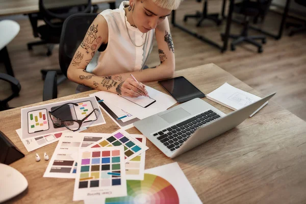 Responsief ontwerp. Jong en mooi creatief vrouwelijk ontwerper maakt een schets tijdens het zitten op haar werkplek in het kantoor — Stockfoto