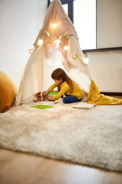 Dunia fantasi. Gadis kecil yang lucu bersenang-senang, bermain di tendanya, wigwam di kamar anak-anak. Pendidikan anak, konsep kegiatan rekreasi — Stok Foto