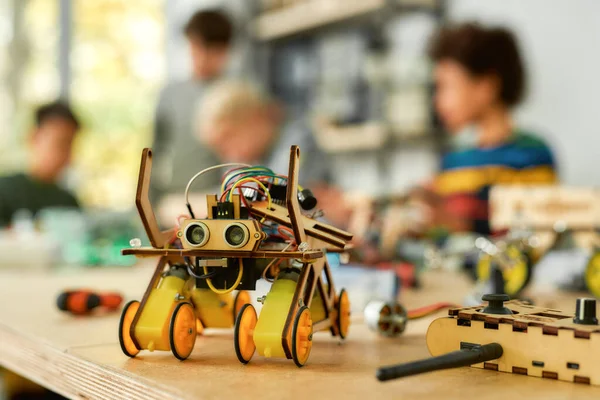 Fantasie am Werk. Nahaufnahme eines gelben Roboterfahrzeugs, das von Kindern bei einem Stammrobotikkurs hergestellt wurde. Erfindungen und Kreativität für Kinder. — Stockfoto