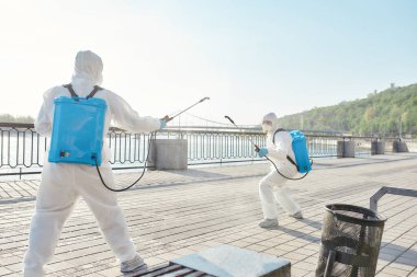 Temizlik tamam. Covid19 virüsünün ortaya çıkmasından dolayı şehrin temizlenmesi, temizlenmesi ve dezenfekte edilmesi. Koruyucu giysiler ve maskeler içinde özel bir ekip çalışırken eğleniyor.