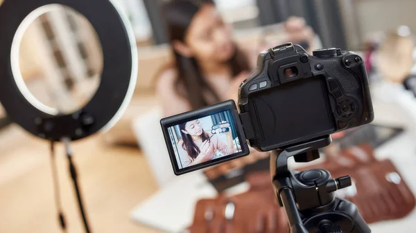 Remain social. Asian female blogger showing cosmetic products while recording a tutorial video for her beauty blog using camera at home — Stock Photo, Image