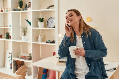 Haberler iyi. Genç, güzel, güler yüzlü bir kadın arkadaşlarıyla ya da müşterileriyle telefonda konuşuyor. Evde çalışırken kahve ya da çay içiyor.