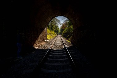 Pohled do tunelu, kterm vedo vlakov koleje. Svtlo na konci tunelu.