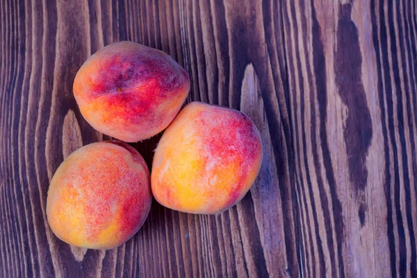 Juicy peaches on wooden background