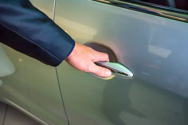 İş adamı el araba doorhandle tutarak