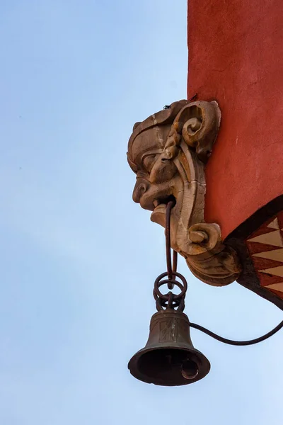 Glocke hängt von Mascaronkopf an Gebäude — Stockfoto
