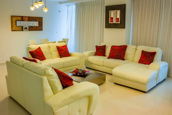 Foyer of hotel with white sofas and red cushions