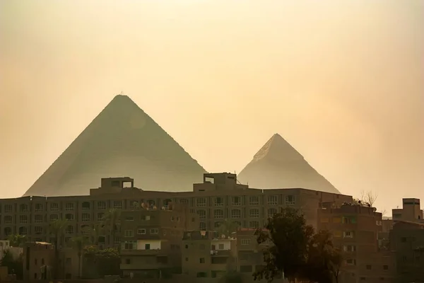 Las grandes pirámides se elevan más allá de la ciudad de Giza —  Fotos de Stock