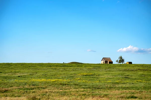 Old lonely house in the field on sunny day — Stock Photo, Image