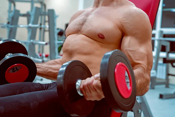 Athlète masculin faisant de l'exercice biceps avec haltères — Photo