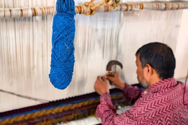 Vista trasera hombre teje alfombra —  Fotos de Stock