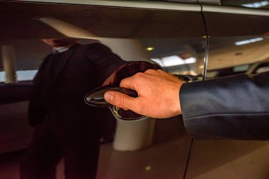 İş adamı el araba doorhandle tutarak