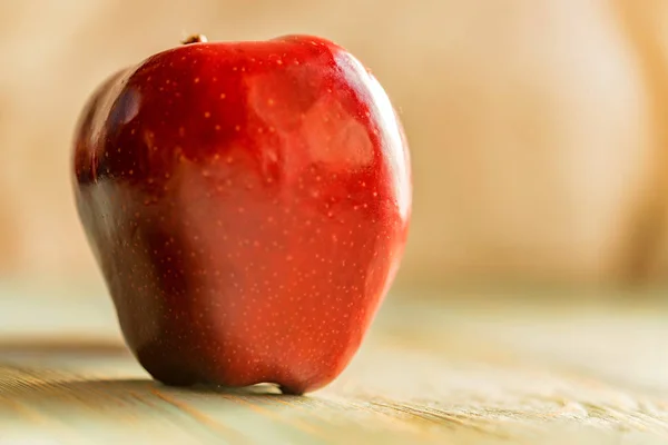 Red juice ripe apple on wooden background