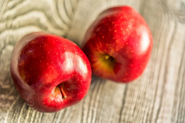 De rijpe appels rood sap op houten achtergrond — Stockfoto
