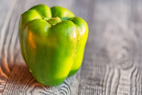 Large green bell paprika pepper on cutting board — Stock Photo, Image