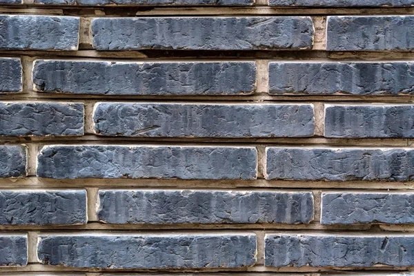 Antiguo muro de ladrillos de piedra gris oscuro — Foto de Stock