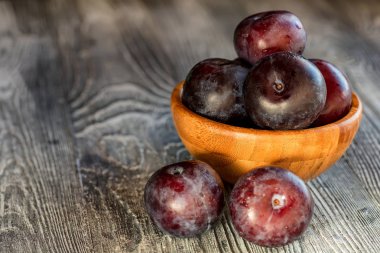 Ahşap masa üzerinde bir kapta Bahçe Erik