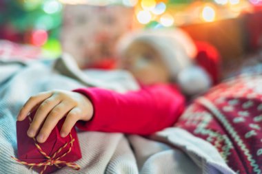 Noel ağacının yanında uyuyan sevimli küçük bebek kız