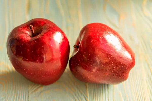 Suco vermelho maçãs maduras no fundo de madeira — Fotografia de Stock