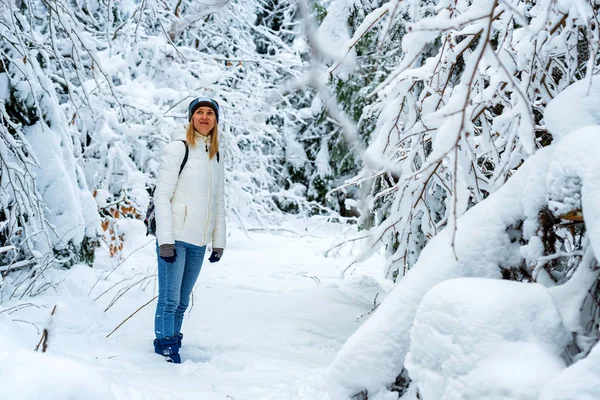 Jonge vrouwelijke wandelaar in de winter bergbos — Stockfoto