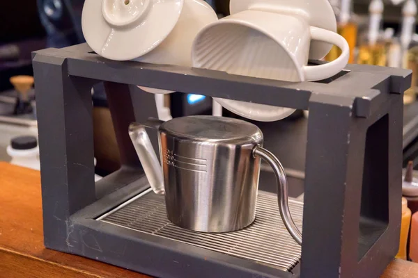 Metal kettle and white cups dry in kitchen — Stock Photo, Image