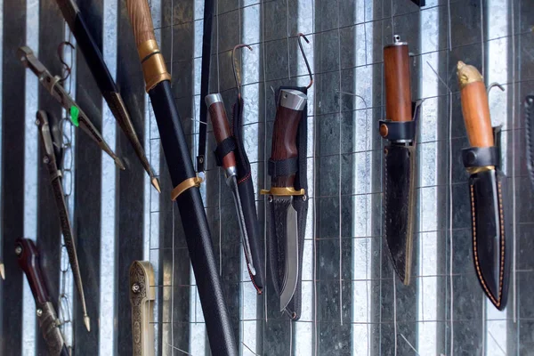 Verschiedene Messer und Schwerter hängen zum Verkauf an der Wand — Stockfoto