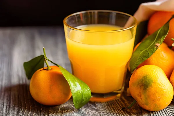 Glass of fresh juice and mandarins on table — Stock Photo, Image