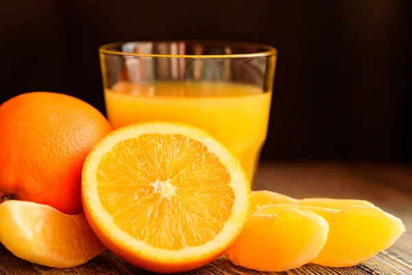 Naranjas y zumo de naranja sobre fondo de madera —  Fotos de Stock