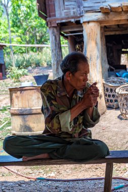 Bangkok, Tayland - Mart 2013 yaklaşık: Kimliği belirsiz taşralı bir sigarette ışıklar