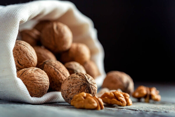 Walnuts in sack on wooden backgound