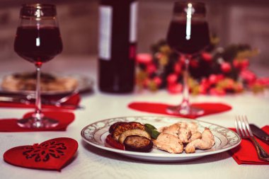 Şarap, kalp, çiçekler ile iki kişilik romantik bir akşam yemeği