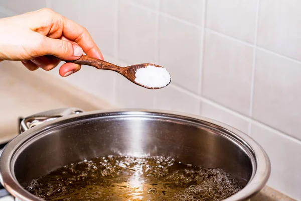 Adding salt in boiling water, cooking soup — Stock Photo, Image