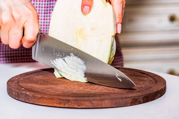 Female hands cut cabbage on wooden board — Stock Photo, Image