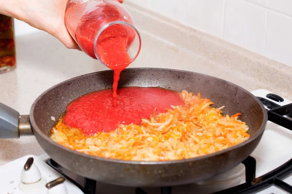 Добавление томатной пасты в овощи для борща — стоковое фото
