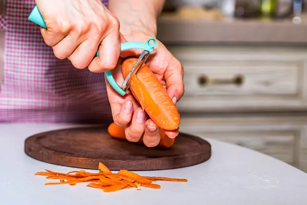 Womans hand peel carrot close — Stock Photo, Image
