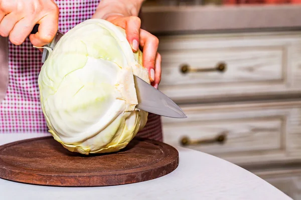 Female hands cut cabbage on wooden board — Stock Photo, Image