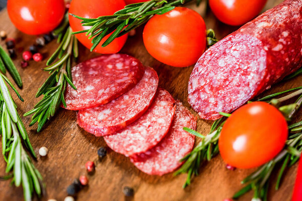 Вкусная салями с помидорами и перцем рядом
