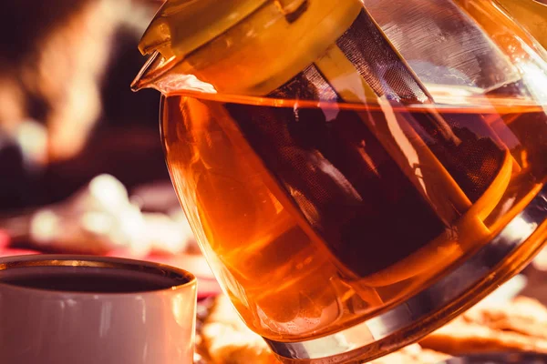 Pouring tea from transparent kettle in cup — Stock Photo, Image