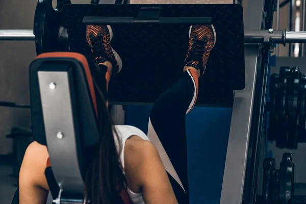 Joven mujer deportiva hace ejercicios de piernas en el gimnasio — Foto de Stock