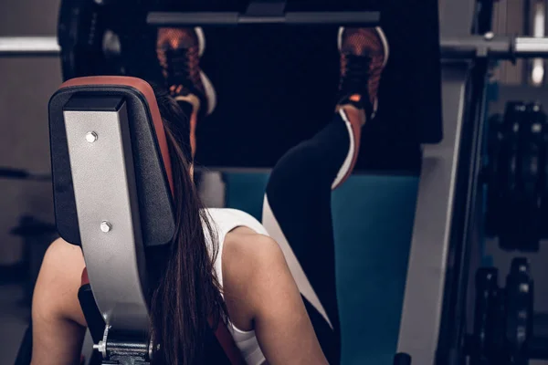 Joven mujer deportiva hace ejercicios de piernas en el gimnasio — Foto de Stock