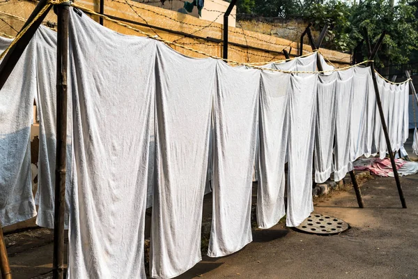 Weiße Laken hängen an Seilen in indischer Straße — Stockfoto