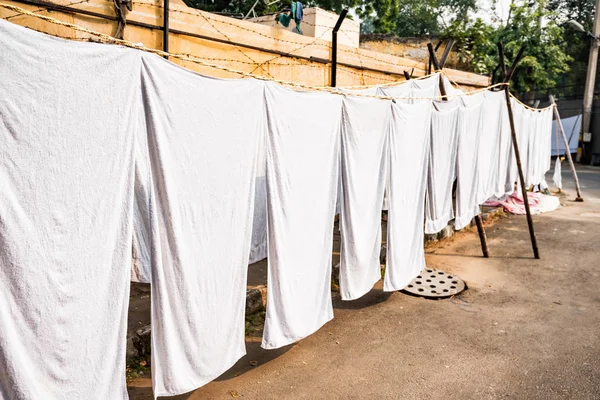Las sábanas blancas cuelgan de las cuerdas en la calle India —  Fotos de Stock
