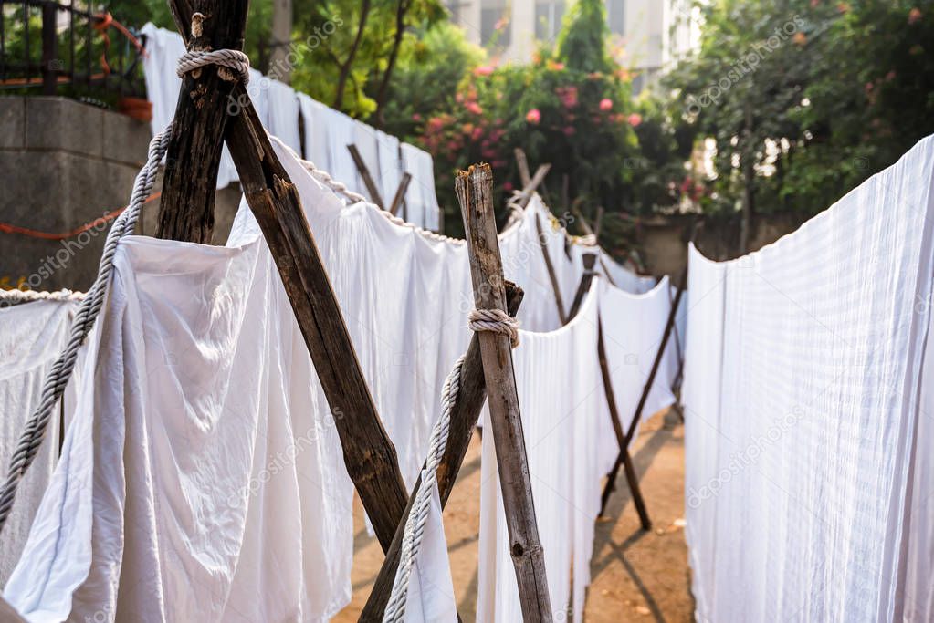 White sheets hang on ropes in Indian street