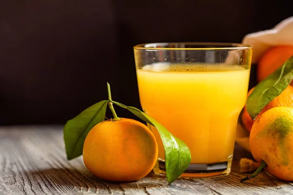 Glass of fresh juice and mandarins on table — Stock Photo, Image