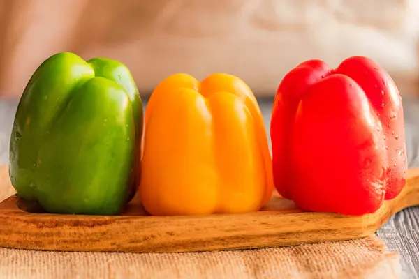 Variety of bell paprika peppers on cutting board — Stock Photo, Image