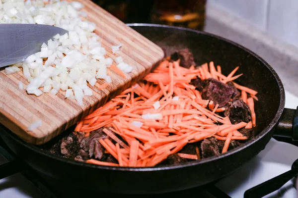 Închide adăugarea de ceapă tocată la tocană de carne de vită — Fotografie, imagine de stoc