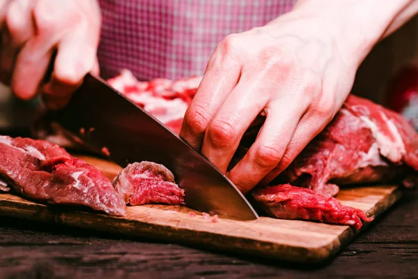 Женские руки режут сырую говядину близко. — стоковое фото