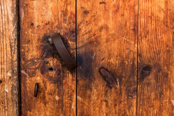 Old wooden door with broken metal handle close