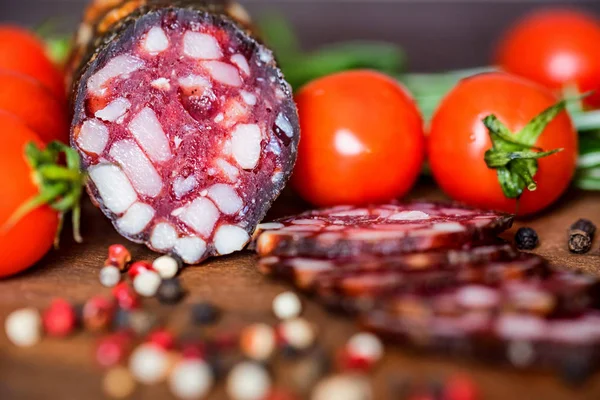 Tasty salami with tomatoes and peppercorn close — Stock Photo, Image